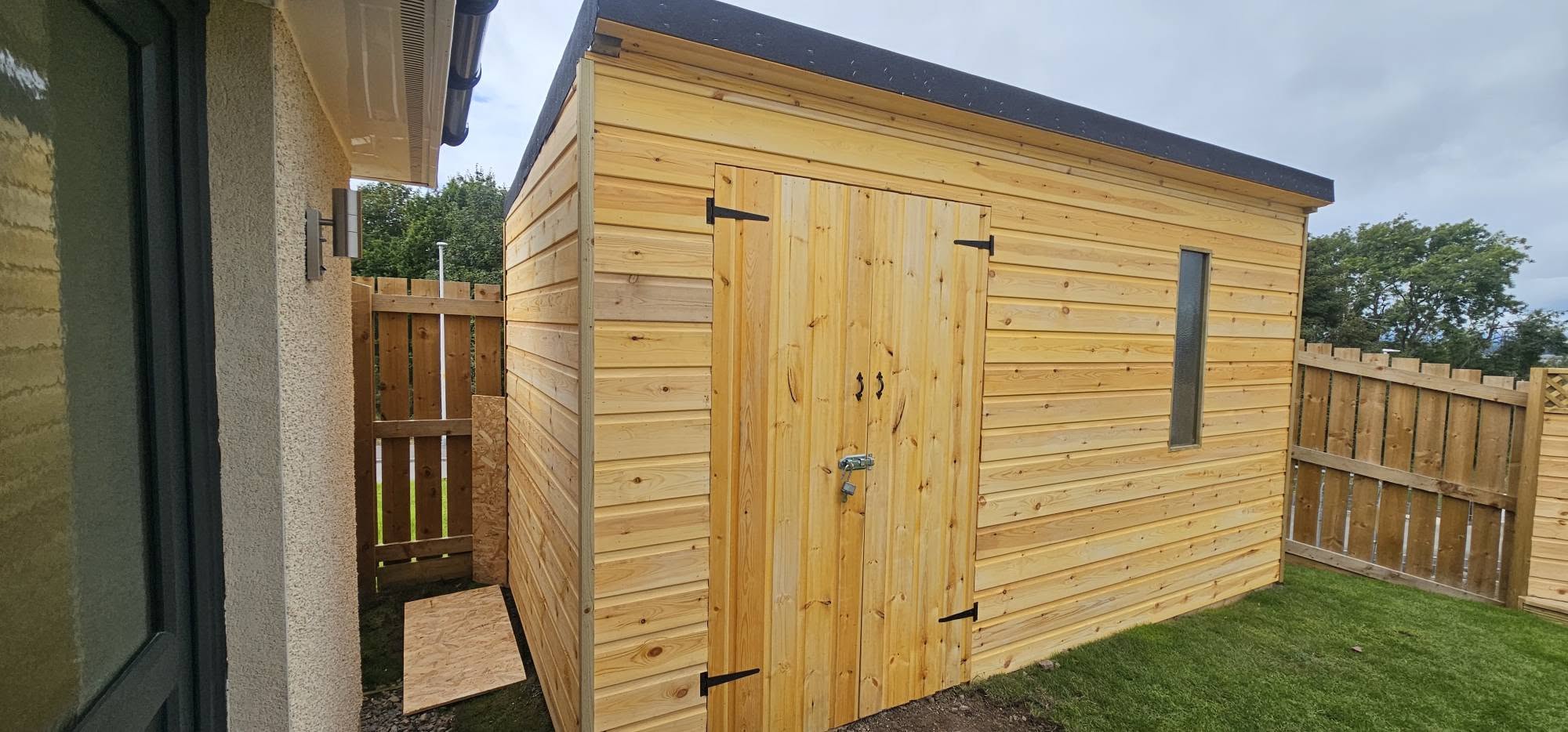 A bespoke timber shed with double doors, built by A.P. Joinery Services